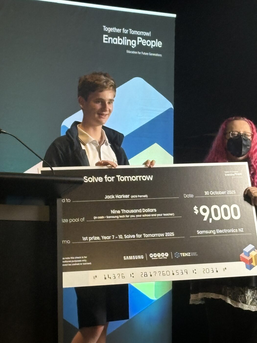 Jack Harker speaking at the podium with the Samsung cheque